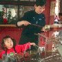 Japan - Kyoto -  Girl and mother drinking from communal fountain.